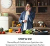A man is on the phone in a kitchen with various ingredients on the counter. Produktbild-Vorschau