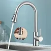 A stainless steel kitchen faucet with a pull-down sprayer is shown in use over a sink. Produktbild-Vorschau