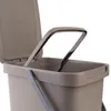 A close-up view of the top part of a brown plastic trash can with its lid open and a gray handle. Podgląd zdjęcia produktu
