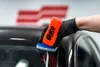 A gloved hand is applying a product to a car's windshield. Produktbild-Vorschau