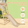 A wooden climbing frame with a slide, set against a green background with trees visible in the background. Produktbild-Vorschau
