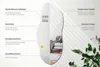 A mirror with descriptive text overlays highlighting its features, set against a light background with shadows and some greenery. Produktbild-Vorschau