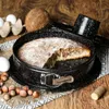 A marble cake in a springform pan, surrounded by baking ingredients like eggs, hazelnuts, and a coconut. Anteprima dell’immagine prodotto