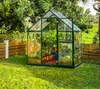A greenhouse filled with plants in a garden setting. Podgląd zdjęcia produktu