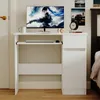 A white computer desk with a monitor, keyboard, and drawers, set in a room with a bed and a door. Podgląd zdjęcia produktu