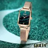 A close-up shot of a rectangular wristwatch with a green dial and a gold mesh strap, set against a sparkling teal and blue background. Produktbild-Vorschau