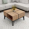 A modern coffee table with a wood-grain finish and black accents is placed on a patterned rug in front of a sectional sofa. Náhľad obrázku produktu