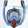 A full-face snorkel mask with dual snorkels is shown partially submerged in water, with blue arrows indicating airflow. Podgląd zdjęcia produktu