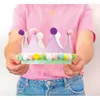 A person wearing a pink shirt and blue jeans is holding a decorated cardboard crown. Podgląd zdjęcia produktu