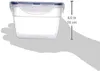 A hand is holding a clear plastic food storage container with a blue lid. Voir les images du produit