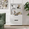 A white bookshelf with drawers, decorated with books and decorative items, next to a green sofa. Podgląd zdjęcia produktu