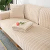 Beiger gesteppter Fleece-Sofabezug auf einem Sofa mit passendem Kissen und gefalteter Decke, eine rosa Rose liegt auf der Decke Náhľad obrázku produktu