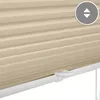 A close-up view of a cream-colored pleated blind with a white clamping mechanism visible at the bottom. Produktbild-Vorschau