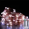 A coiled string of white LED lights with a copper wire, next to a remote control. Produktbild-Vorschau