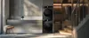 A modern laundry room with stacked washing machines and a closet with clothes and stairs. Voir les images du produit