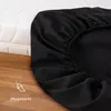 A black fitted sheet is shown draped over a white mattress, with a wooden floor in the foreground. Produktbild-Vorschau