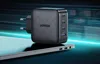A black UGREEN GaN Tech fast wall charger with multiple USB-C ports and one USB-A port is shown on top of a laptop. Produktbild-Vorschau