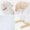 A collage of four close-up images of a white, fluffy sheep rocking toy for children. The images show the head and ears, the seat area, the texture of the material, and the wooden rocking base and feet. Produktbild-Vorschau