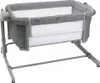 A gray and white co-sleeper bassinet is shown against a white background. Produktbild-Vorschau