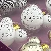 A close-up view of several decorative ornaments, likely for a Christmas tree, with a purple background. Produktbild-Vorschau