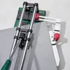 A close-up view of a tile cutter with a piece of tile. Produktbild-Vorschau