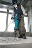 A person is using a demolition hammer to break concrete. Anteprima dell’immagine prodotto