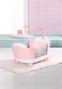 A pink and white toy bathtub with a shower head attachment, sitting on a pink mat. Produktbild-Vorschau
