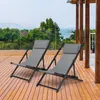 Two grey lounge chairs on a wooden deck overlooking a body of water with trees and buildings in the distance. Voir les images du produit