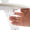 A hand is pressing a white plastic button on a white wooden high chair. Náhled obrázku produktu