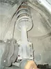 A close-up view of a car's suspension system, specifically a strut and coil spring assembly, with a brake caliper visible. Voir les images du produit