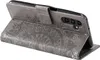 A gray flip case for a smartphone with a mandala pattern embossed on the front. Produktbild-Vorschau