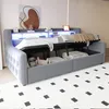 A grey upholstered daybed with storage compartments underneath and a shelf with LED lighting above. Voir les images du produit