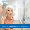 A split image showing an elderly woman looking in a mirror on the left and a modern bathroom with a bathtub and shower on the right. A blue banner with text is at the bottom. Anteprima dell’immagine prodotto