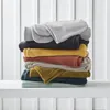 A stack of folded blankets in various colors. Podgląd zdjęcia produktu