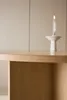 A close-up of a wooden table with a candle in a white holder on it. Voir les images du produit