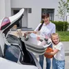 A woman and a girl are loading items into the trunk of a car. Voir les images du produit