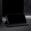 A black flip-style phone case with a phone inside, displayed on a dark surface. Produktbild-Vorschau