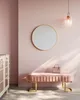 A pink room with a round mirror, a pink bench with a handbag on it, and a cabinet on the left. Produktbild-Vorschau