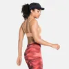 hautfarbenem Sport-BH mit verstellbaren Trägern und roten Leggings mit Wellenmuster Produktbild-Vorschau
