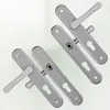 Four silver door handles with escutcheons are arranged diagonally on a light background. Produktbild-Vorschau