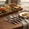 A table setting with cutlery and a cheese and bread platter. Anteprima dell’immagine prodotto