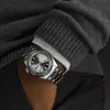 A person wearing a watch and a sweater. Voir les images du produit