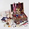 A collection of Harry Potter themed merchandise, including a trunk, lanyards, charms, and other small items, arranged around an open trunk. Produktbild-Vorschau