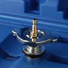 A close-up view of a radiator cap tool with a brass fitting, resting on a blue surface. Podgląd zdjęcia produktu