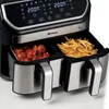 A close-up shot of a black and silver dual-basket air fryer, with one basket filled with meatballs and the other with french fries. Podgląd zdjęcia produktu