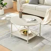 A round coffee table with a lower shelf is placed on a rug in a living room setting. Produktbild-Vorschau