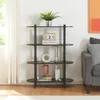 A black four-shelf bookcase filled with decorative items, books, and a plant, set against a white wall with sheer curtains visible to the left and a grey sofa to the right. Náhled obrázku produktu