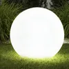 A large, illuminated white sphere sits on a grassy lawn, surrounded by tall green grass and some dark foliage in the background. Produktbild-Vorschau