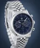 A close-up studio shot of a Maserati men's chronograph watch with a blue dial and a stainless steel bracelet, displayed on a clear stand against a blue background. Náhľad obrázku produktu