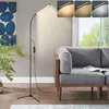 A floor lamp is positioned next to a gray sofa in a living room setting. Produktbild-Vorschau